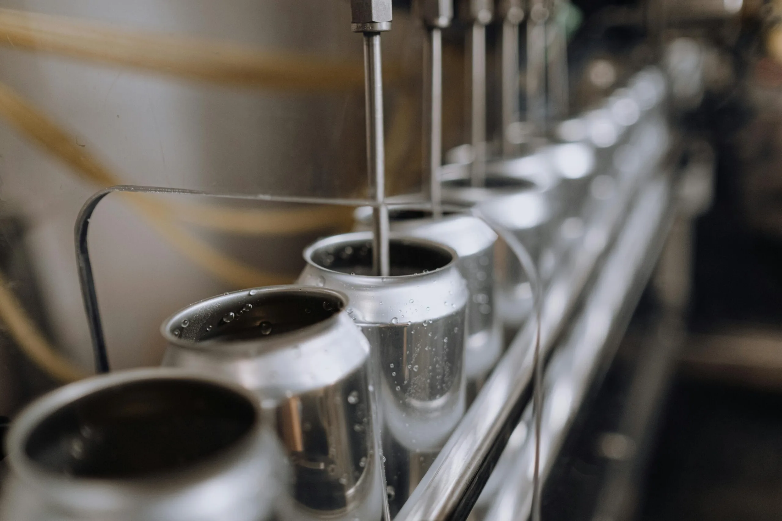pexels-photo-5532672-5532672 Detailed view of an industrial canning process with aluminum cans on an automatic assembly line.
