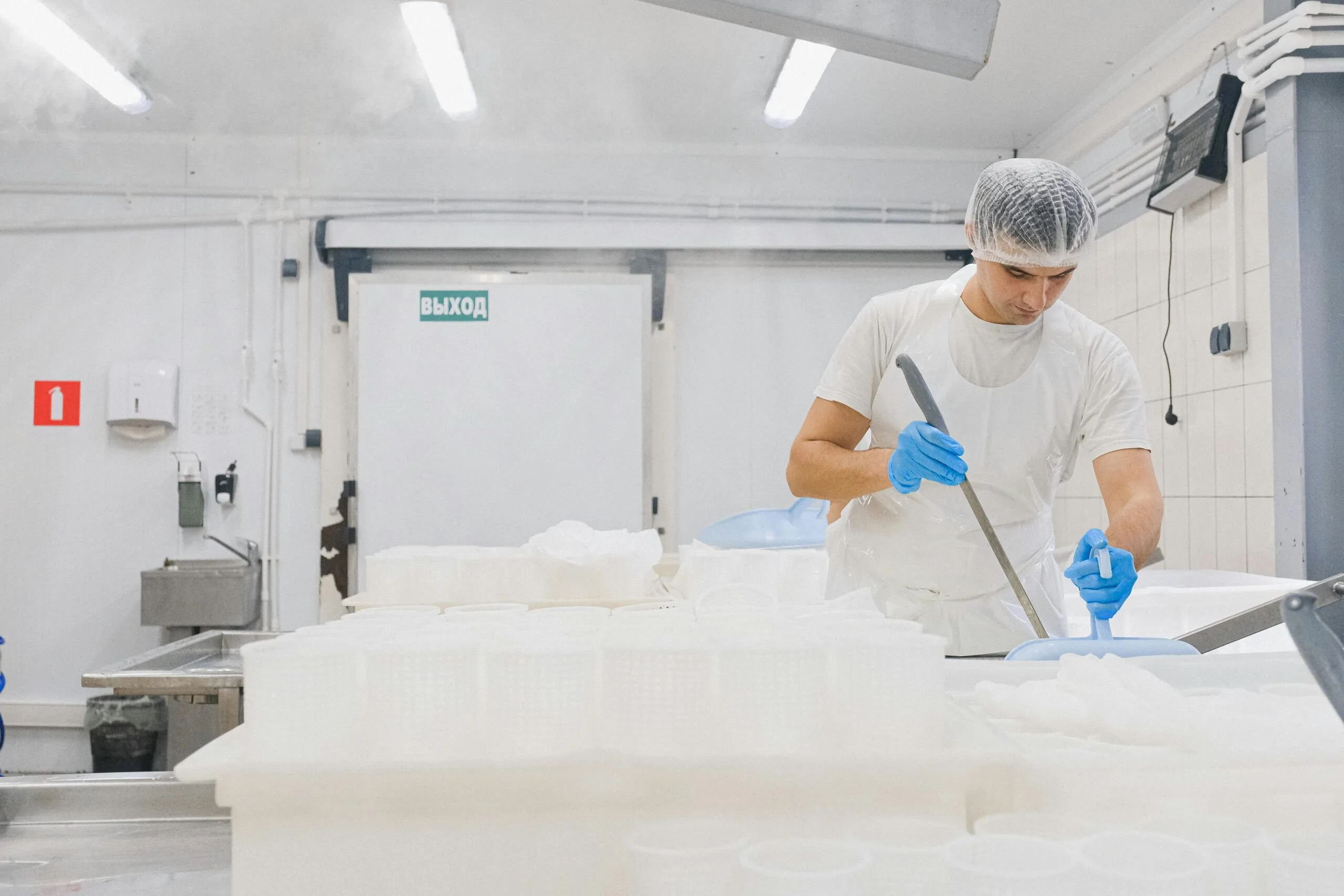 pexels-photo-5953801-5953801 Man in sterile gear working in a cheese production facility, ensuring hygiene standards.