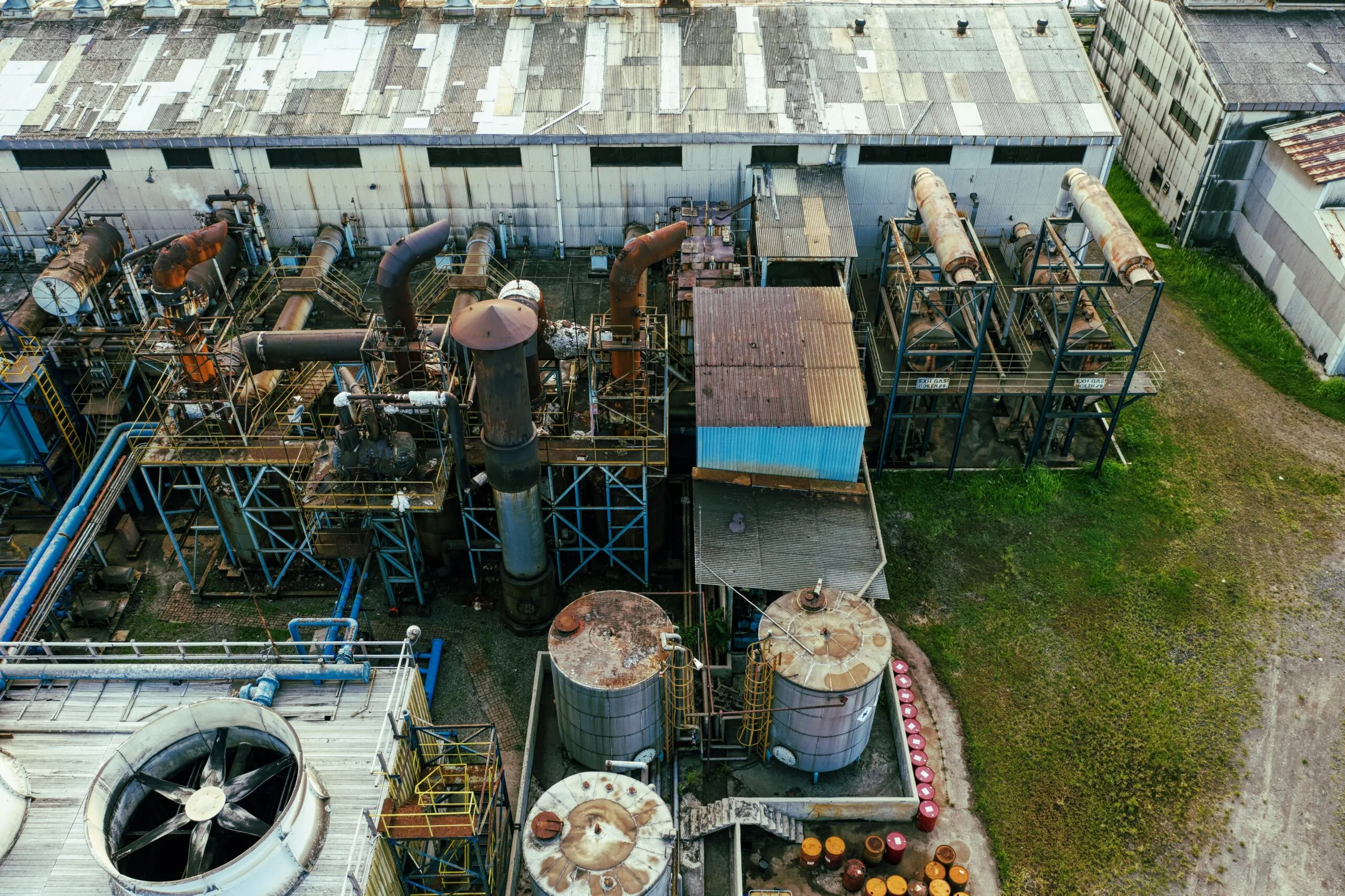 pexels-photo-6060192-6060192 Drone view of industrial area with barrels for petroleum products and pipes connected with warehouses