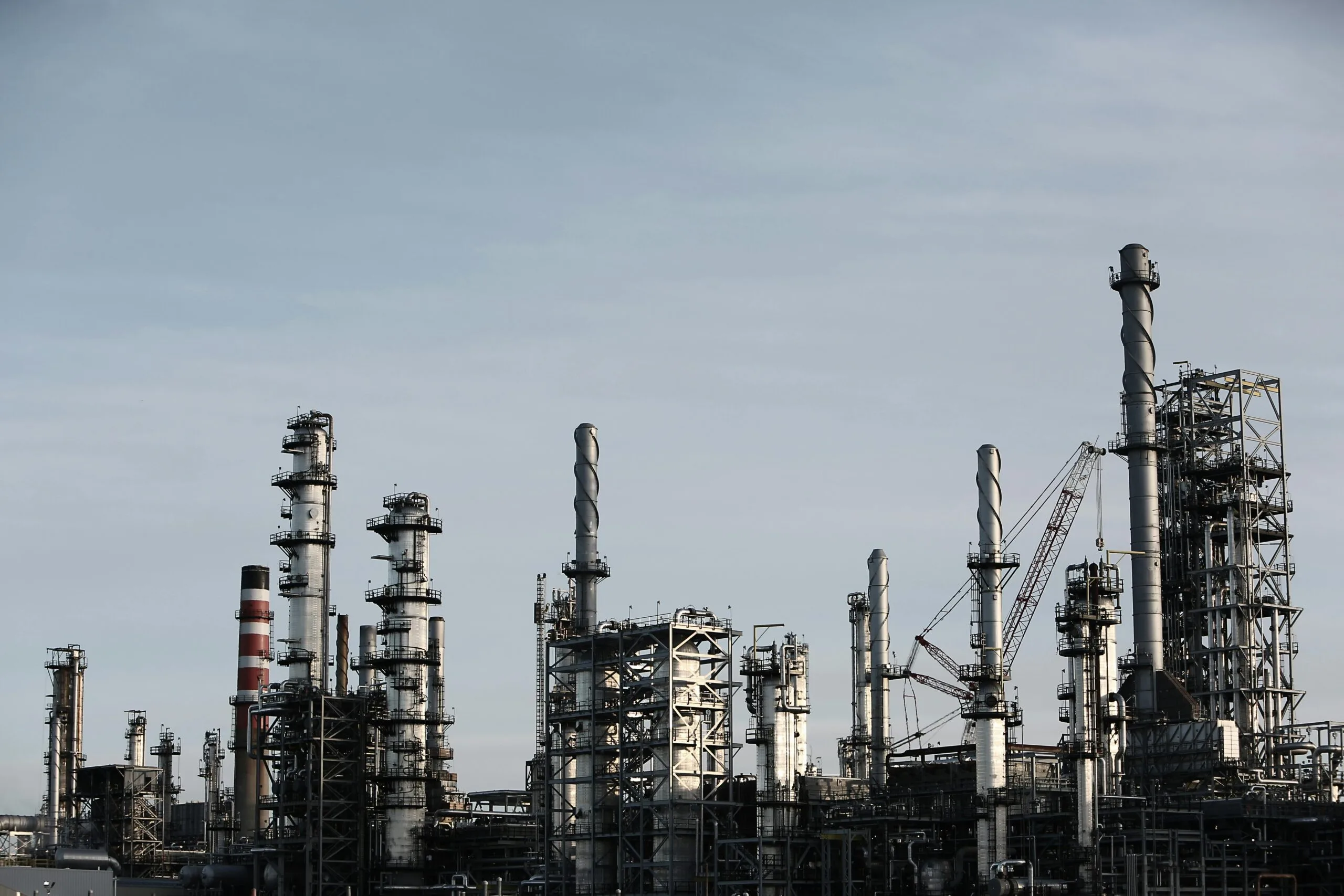 dirty-industry-stack-factory-2391-1 Skyline view of an industrial factory with tall chimneys against a clear sky.