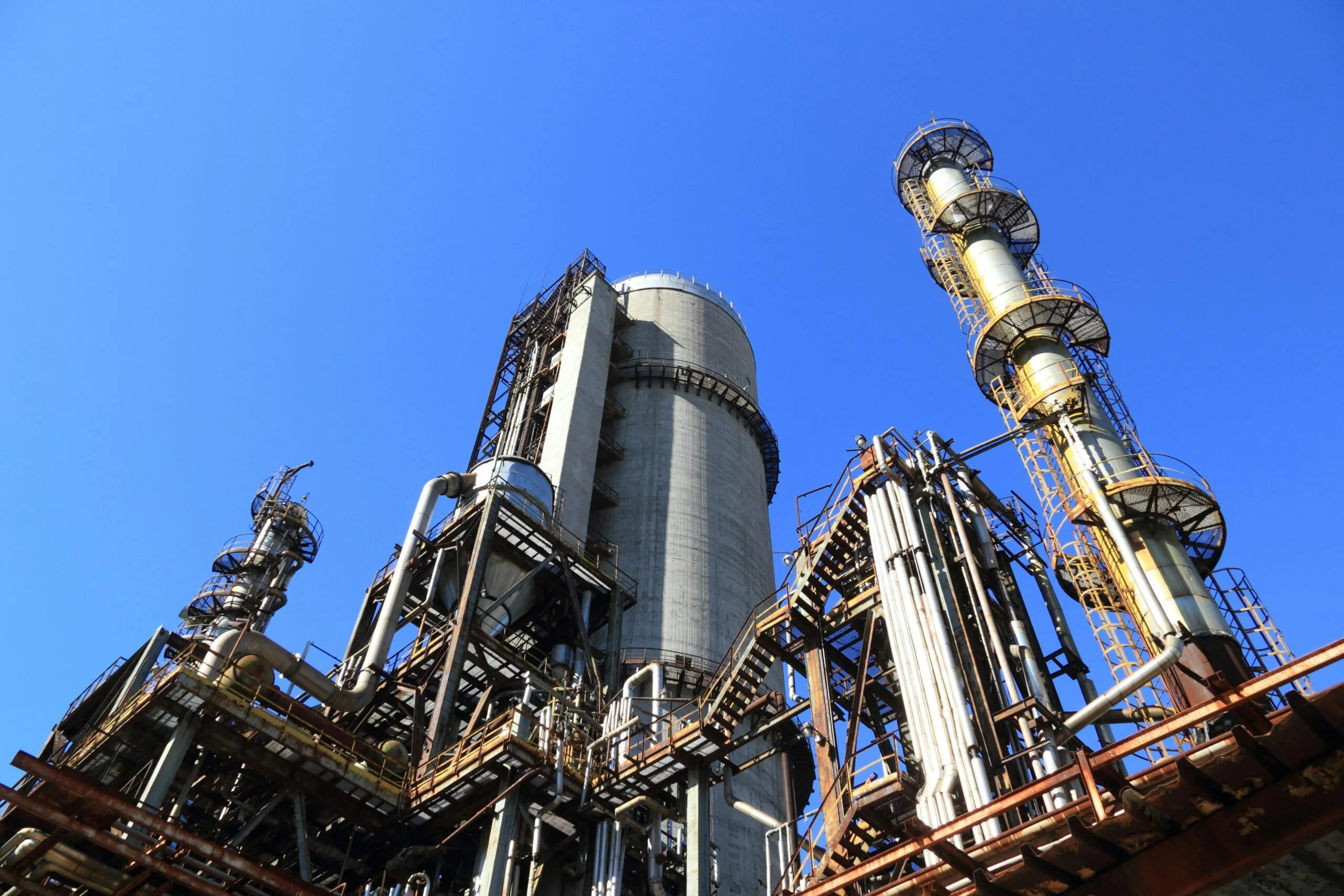 pexels-photo-257700-257700 A towering industrial plant under a vivid blue sky, showcasing its intricate architecture and industrial prowess.