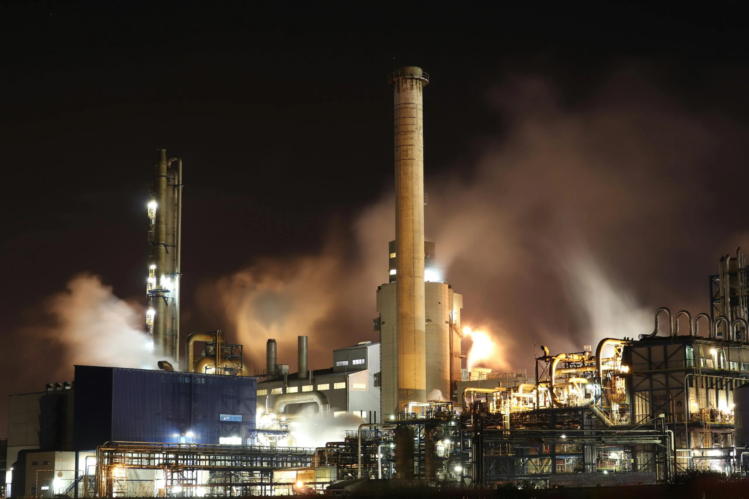 pexels-photo-3855962-3855962 A nighttime view of an industrial factory with smokestacks emitting smoke, highlighting energy production and pollution.