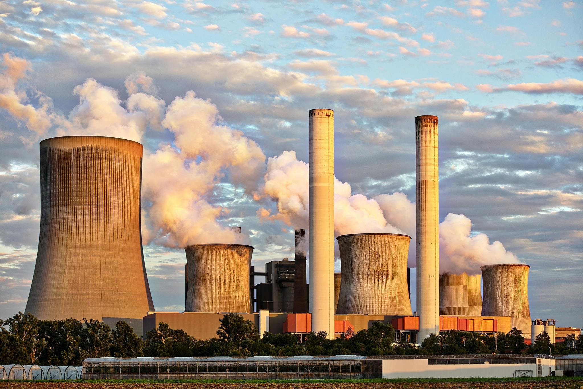 pexels-photo-459728-459728-1 View of a power plant with smoke emissions under a cloudy sky, depicting industrial energy production.