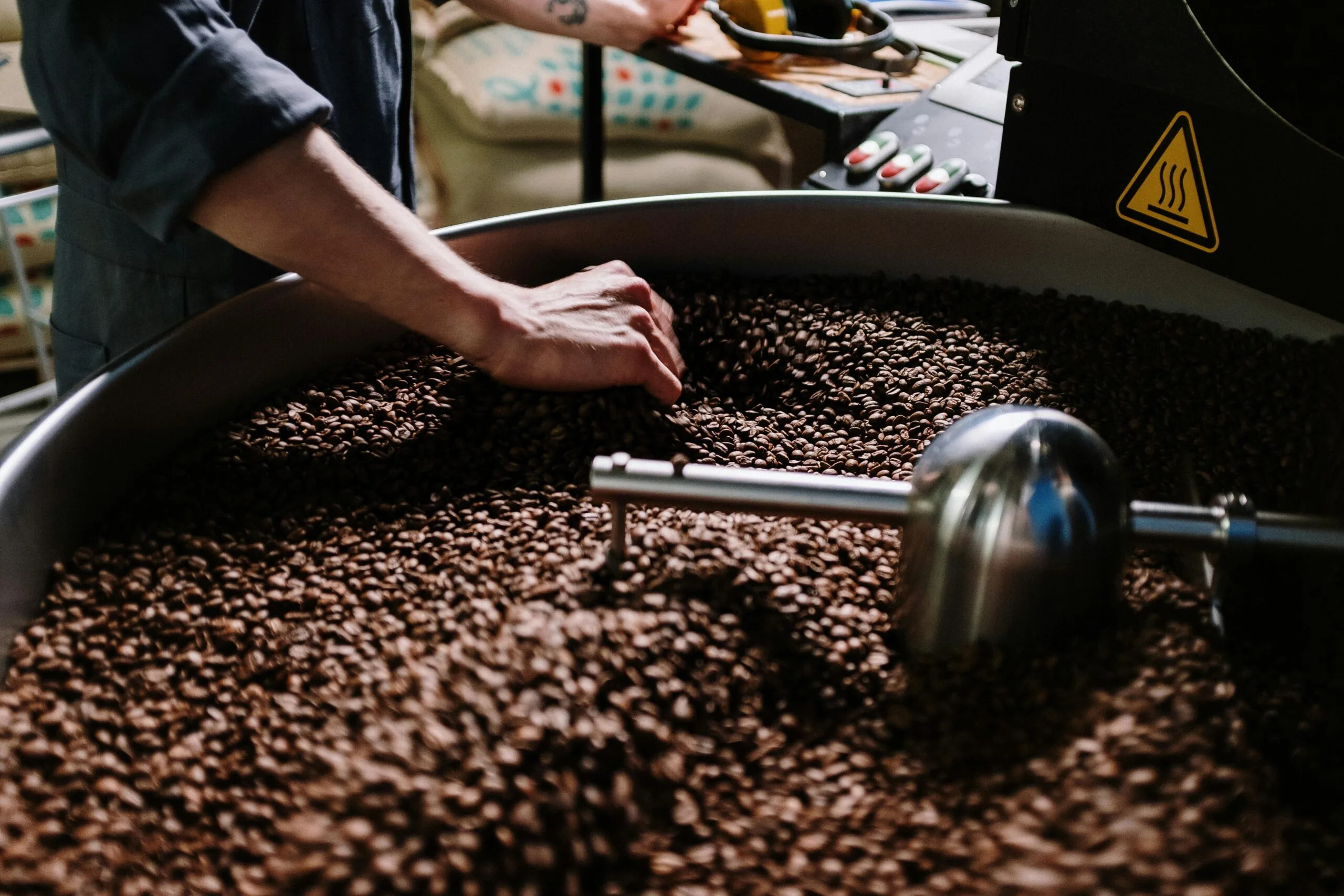 pexels-photo-4820817-4820817 Close-up of a professional roasting coffee beans in an industrial setting, focusing on equipment and beans.